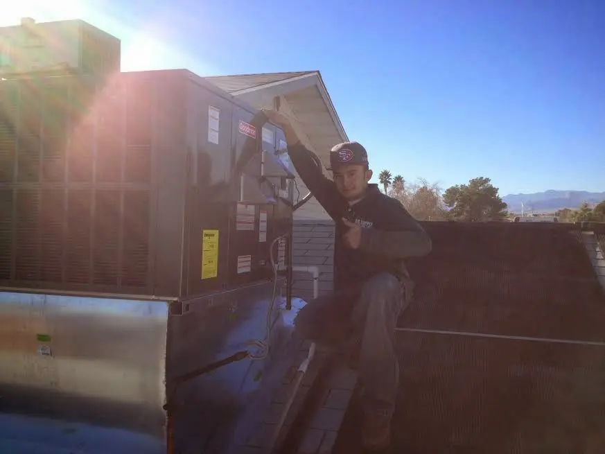 HVAC technician performing Boiler Repair on a rooftop unit in Taylor